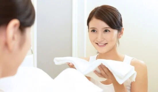 鏡の前でフェイスラインを確かめる女性