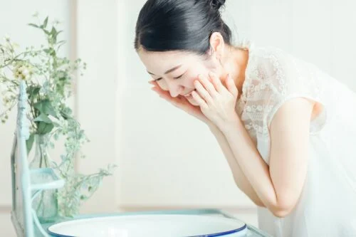 洗顔料の泡で顔をやさしく洗う女性の横顔